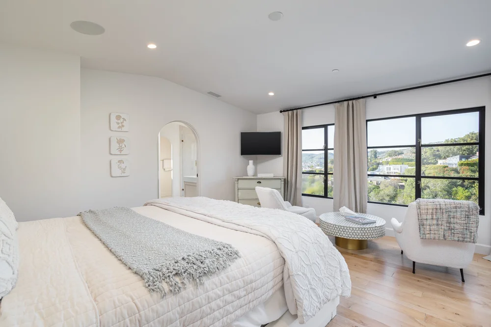 Serene bedroom in soft neutrals with hillside views