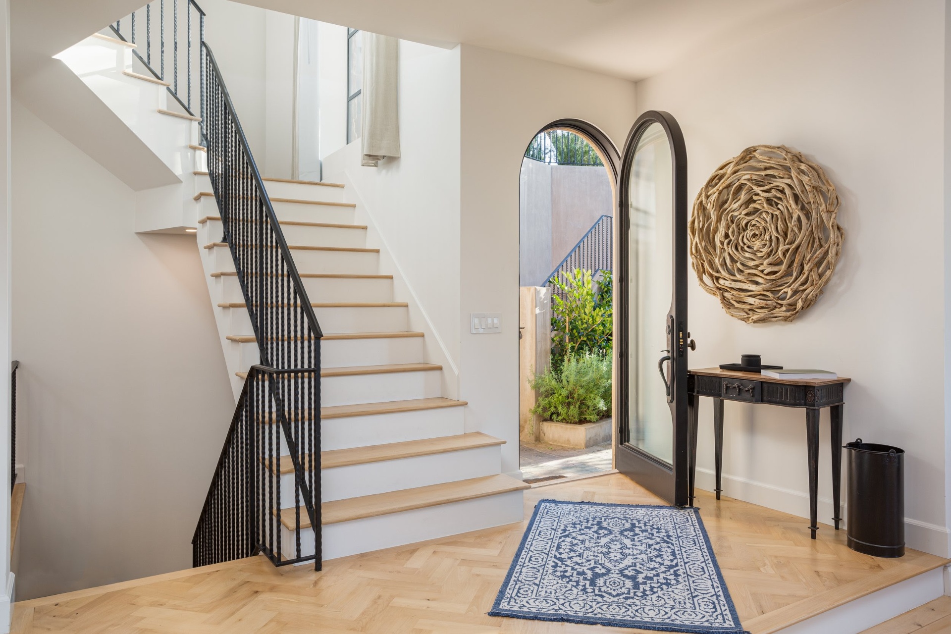 Entry foyer with arched steel door and herringbone floors