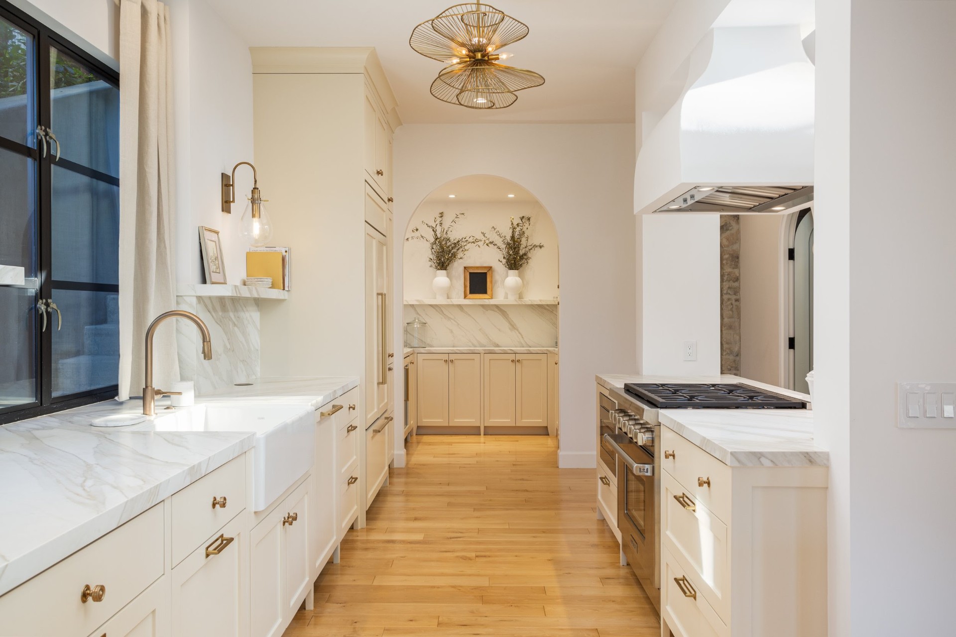 Galley kitchen with marble counters and arched pantry