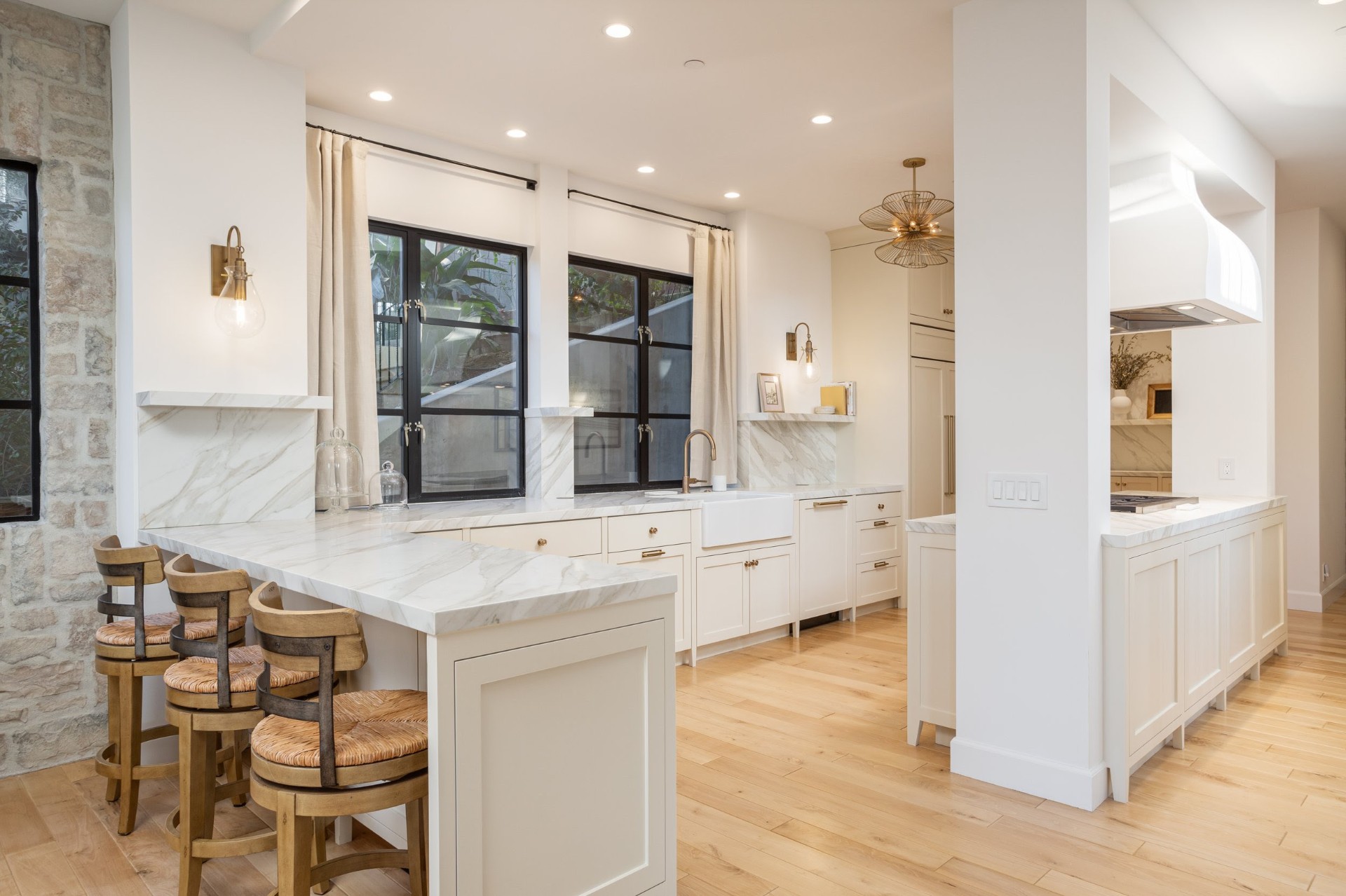 Bright kitchen with marble counters and brass fixtures