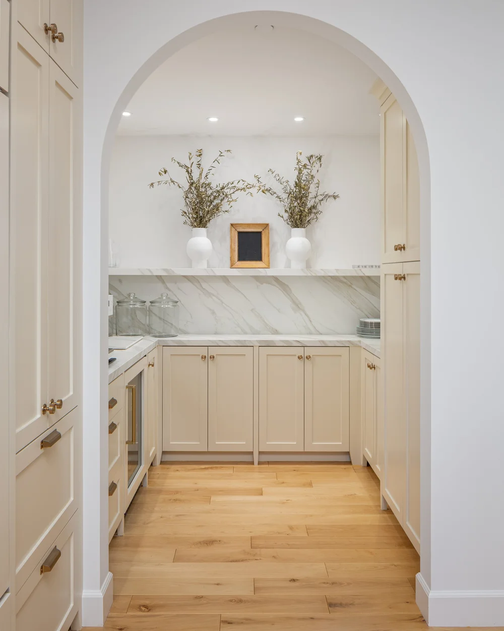Arched butler's pantry with marble shelf and olive branches