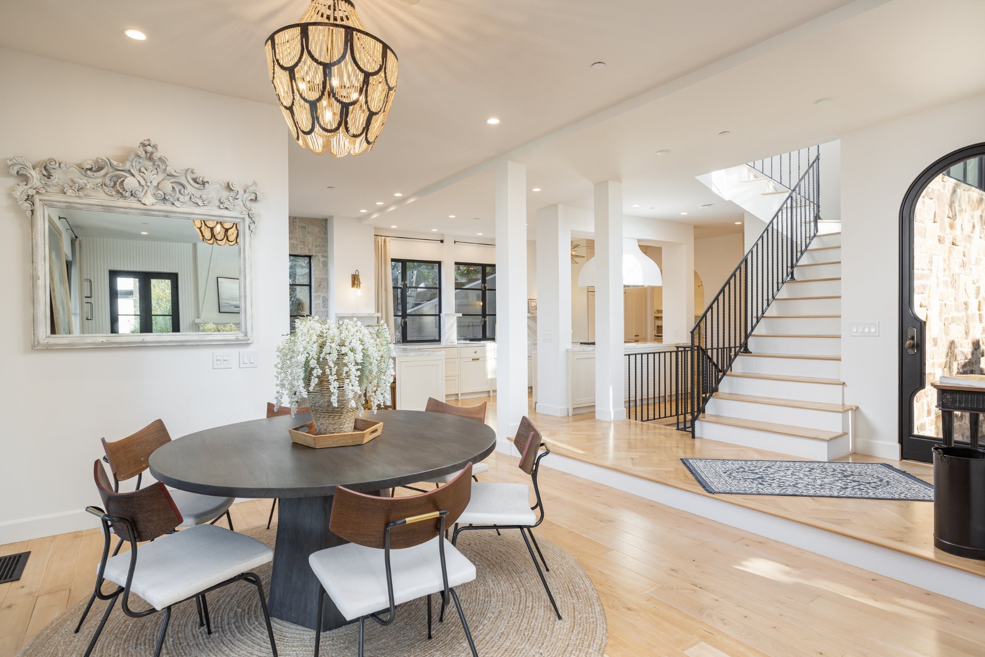 Open dining room with beaded chandelier and staircase