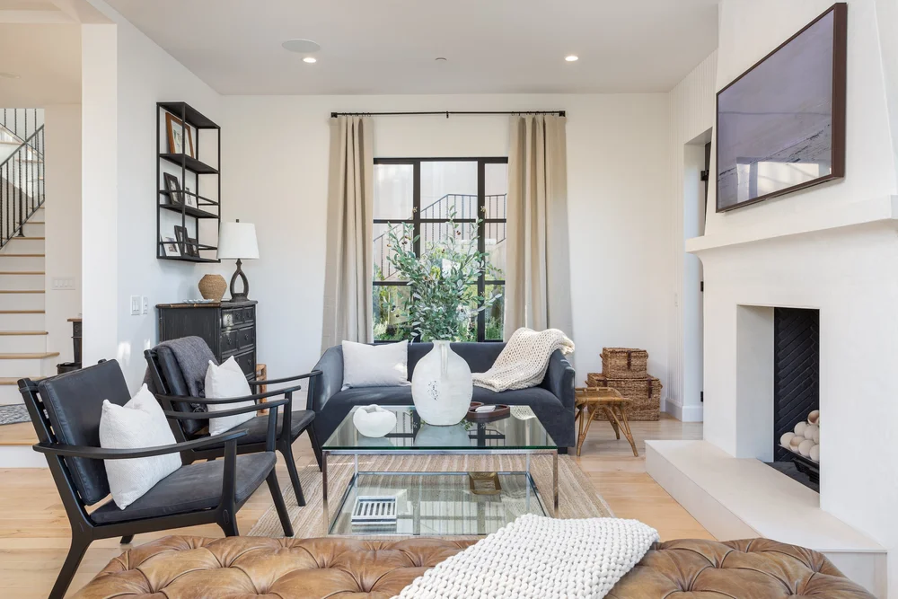 Living room with plaster fireplace and leather ottoman